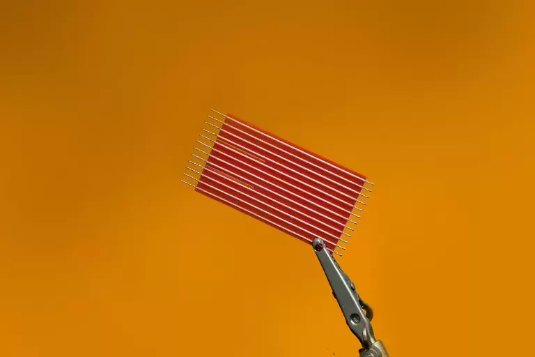 Silver wires attached on red colored flat wrapper.